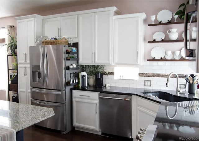 a kitchen with granite countertop a refrigerator and a sink