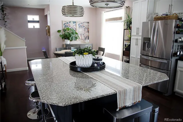 a kitchen with a table chairs and refrigerator
