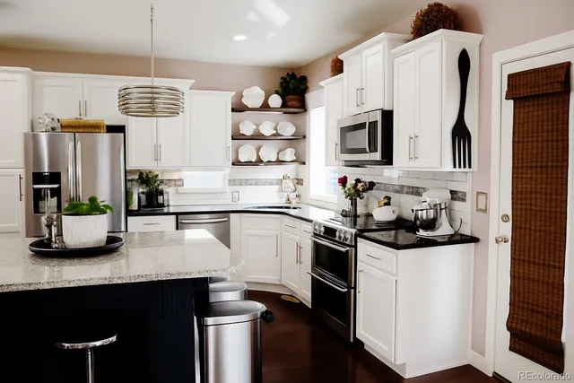a kitchen with stainless steel appliances a sink a stove a microwave a sink a refrigerator and cabinets