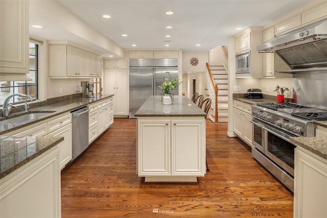 a kitchen with stainless steel appliances granite countertop a sink stove and cabinets