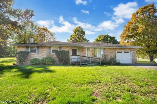 a front view of a house with a garden and yard