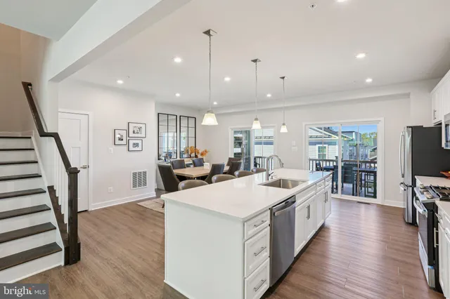 a kitchen with a dining table chairs sink and cabinets