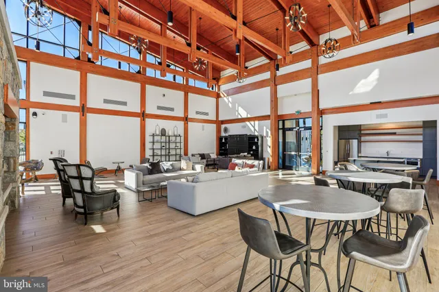 a kitchen with stainless steel appliances a dining table chairs and wooden floor