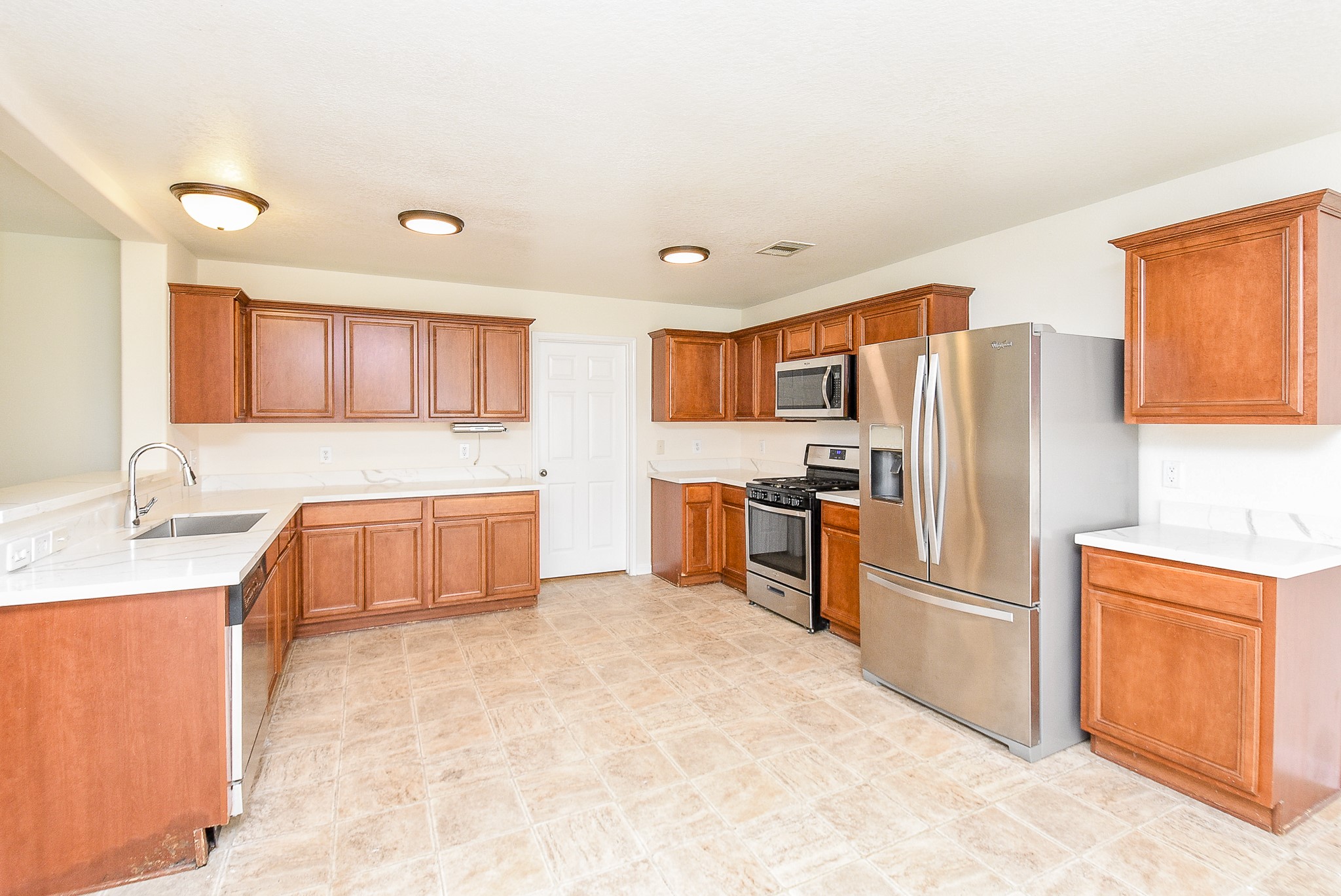 32406 Cross Spring Park Lane Conroe, TX 77385 - Photo 16 of 32 a kitchen with stainless steel appliances a refrigerator sink and cabinets
