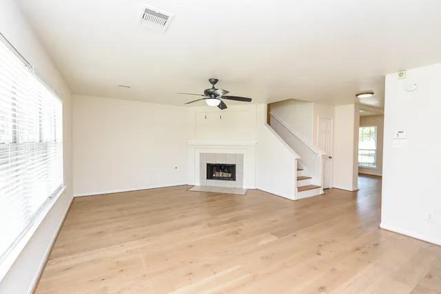 a view of an empty room with a fireplace and a window