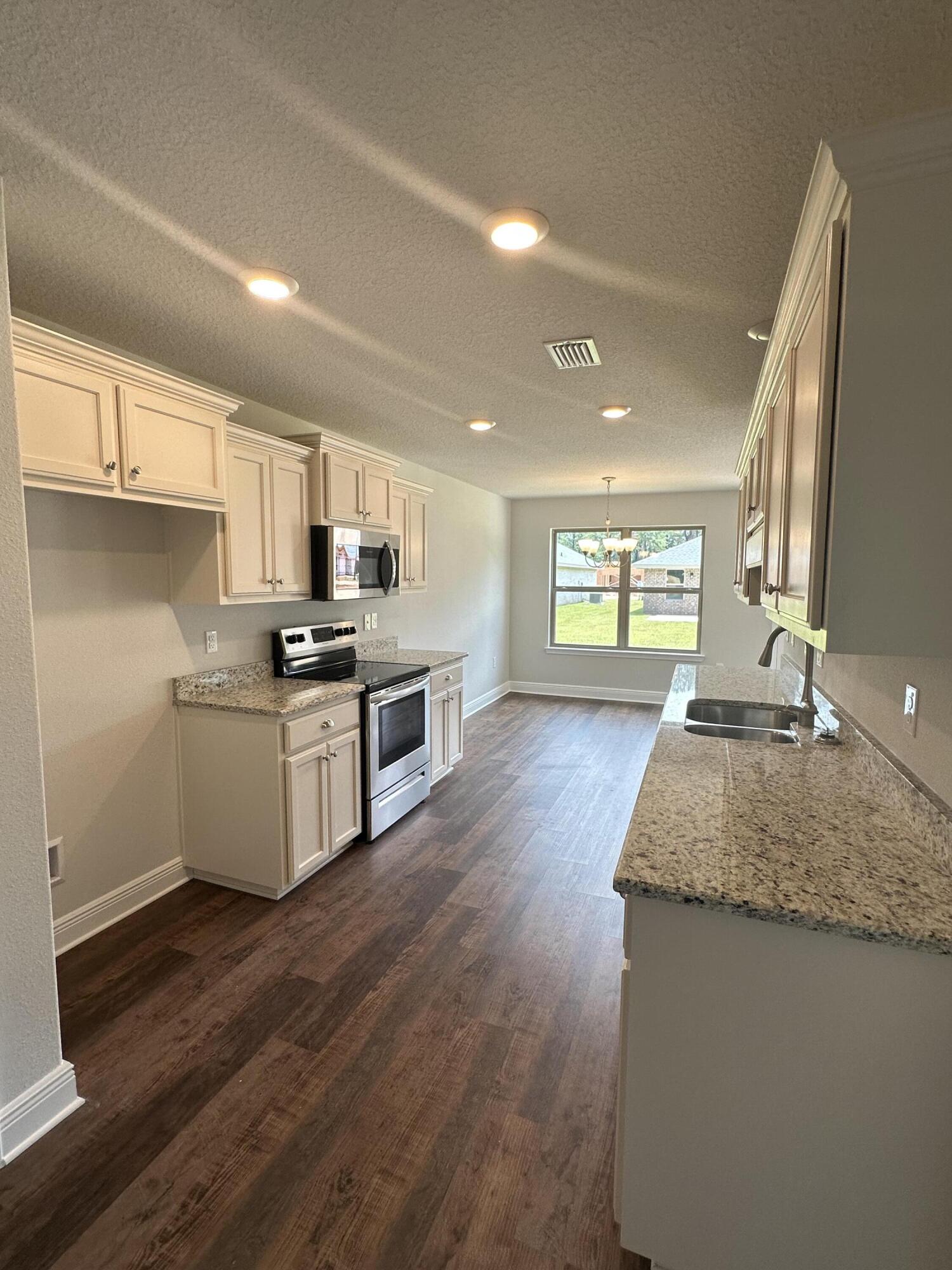188 Ridgeway Circle Crestview, FL 32536 - Photo 8 of 22 a kitchen with stainless steel appliances granite countertop a stove a sink and a refrigerator