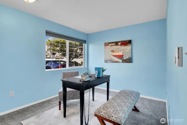a view of a workspace with furniture and window