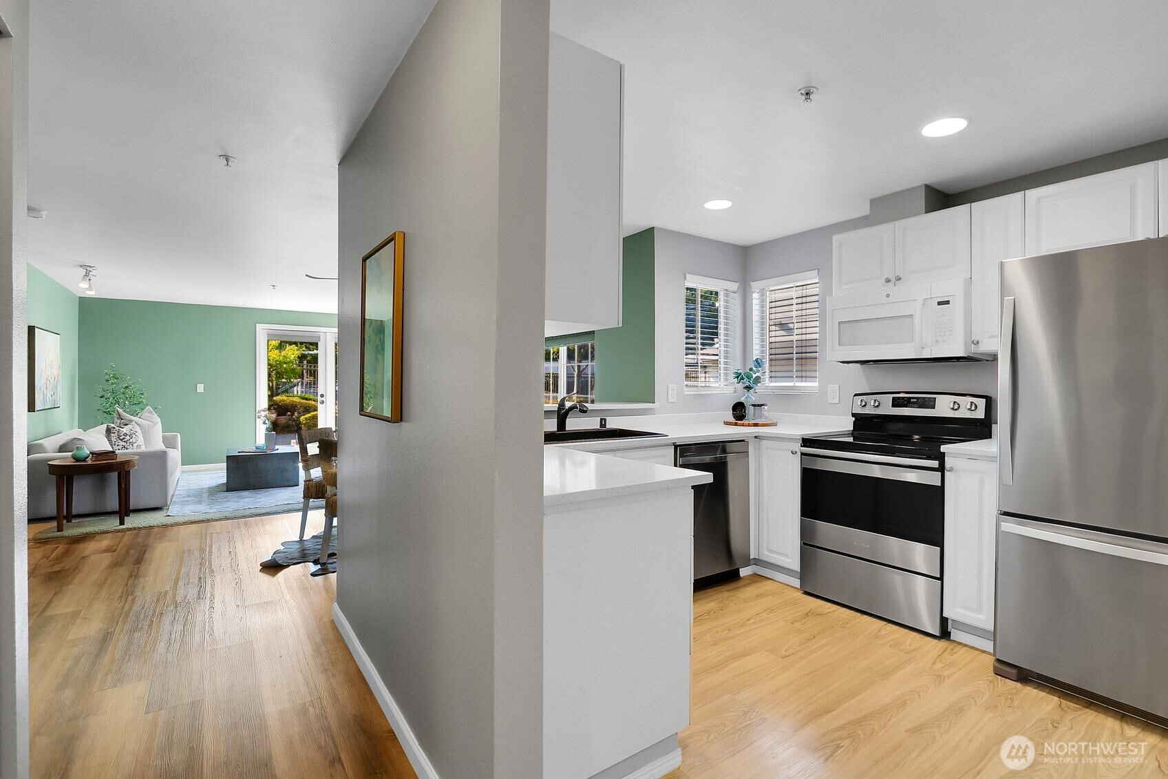 12505 4th Avenue West, Unit 1040 Everett, WA 98204 - Photo 7 of 20 a kitchen with white cabinets and stainless steel appliances