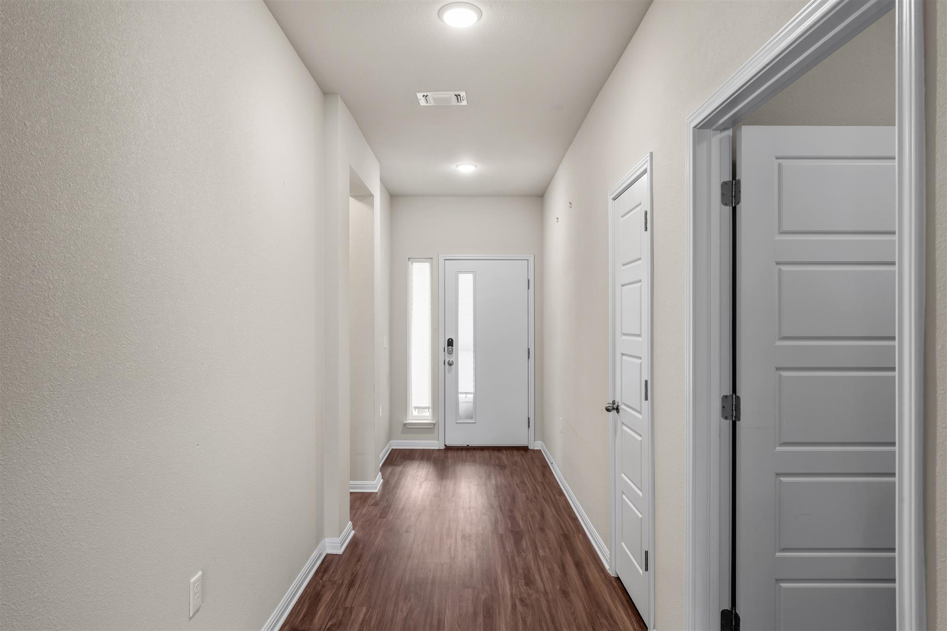 16512 Enamorado Road Manor, TX 78653 - Photo 19 of 31 A welcoming entryway with gleaming wood-look flooring guides guests into the residence.