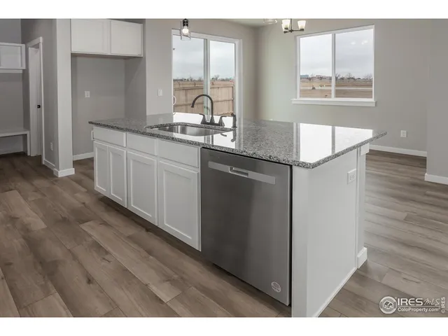 a kitchen with kitchen island granite countertop a sink window and cabinets
