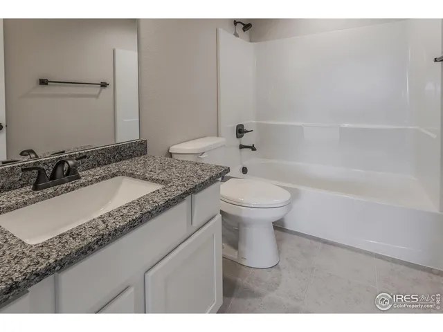 a bathroom with a granite countertop sink a toilet and bathtub