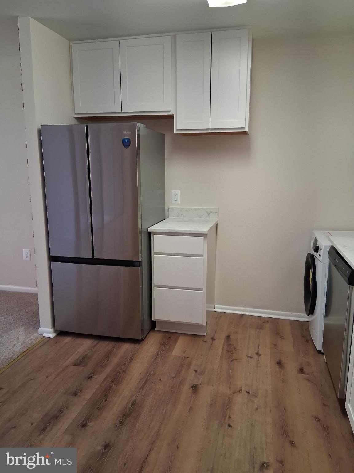 8479 Greenbelt Road, Unit 102 Greenbelt, MD 20770 - Photo 2 of 14 an empty room with wooden floor and cabinets