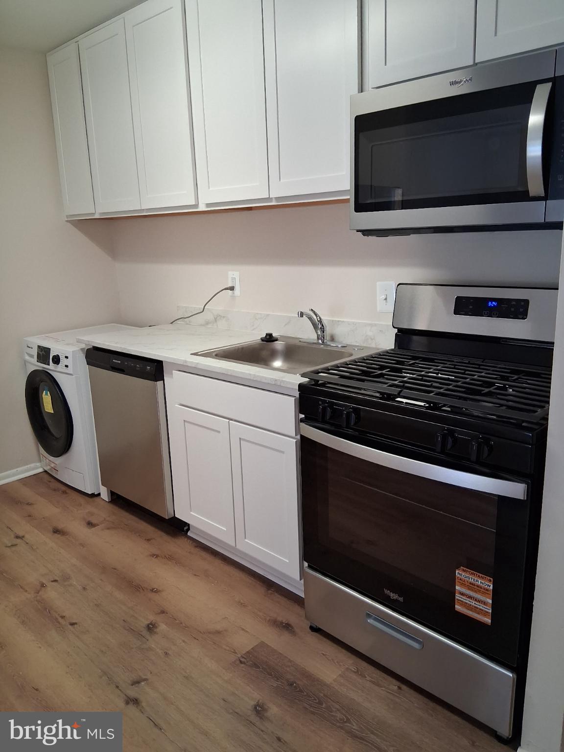 8479 Greenbelt Road, Unit 102 Greenbelt, MD 20770 - Photo 3 of 14 a kitchen with stainless steel appliances granite countertop a stove microwave and sink