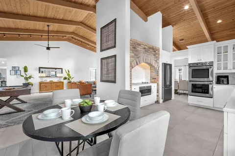 a living room with furniture kitchen view and a large window
