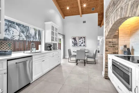 a large white kitchen with a large window
