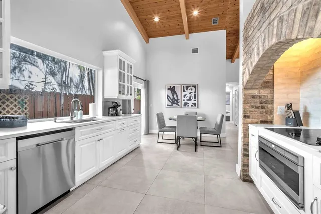 a large white kitchen with a large window
