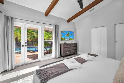 a bedroom with a bed and a large window with the outer view