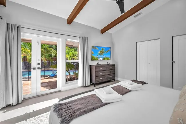 a bedroom with a bed and a large window with the outer view