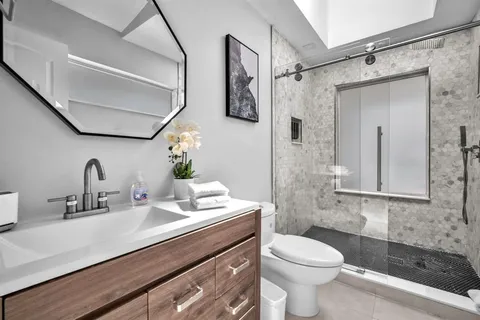 a bathroom with a sink a toilet and shower