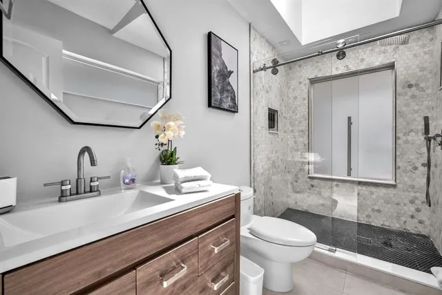 a bathroom with a sink a toilet and shower