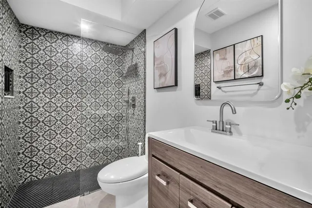 a bathroom with a granite countertop toilet sink and mirror