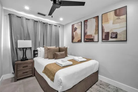 a bedroom with a balcony a bed and a painting on the wall