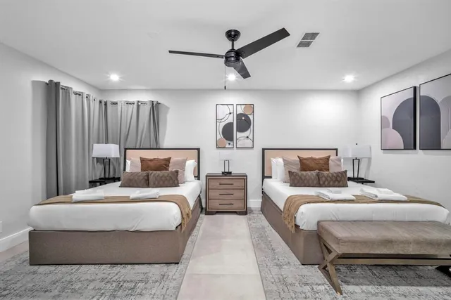 a bedroom with a large bed and a chandelier