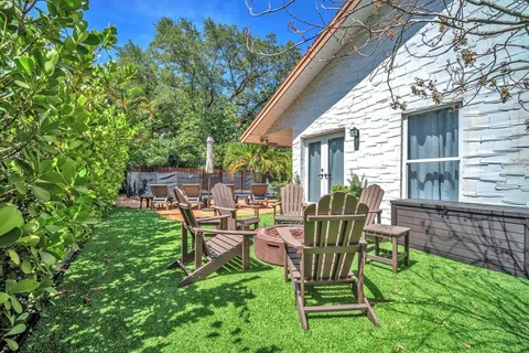 a view of a chair and table in backyard of the house