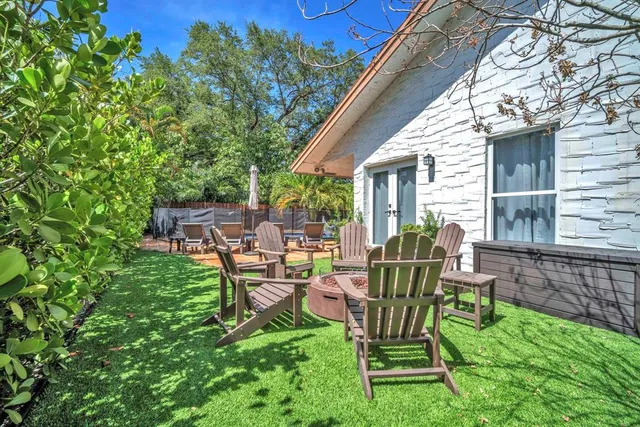 a view of a chair and table in backyard of the house