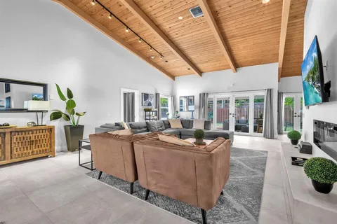 a living room with furniture a flat screen tv and a table
