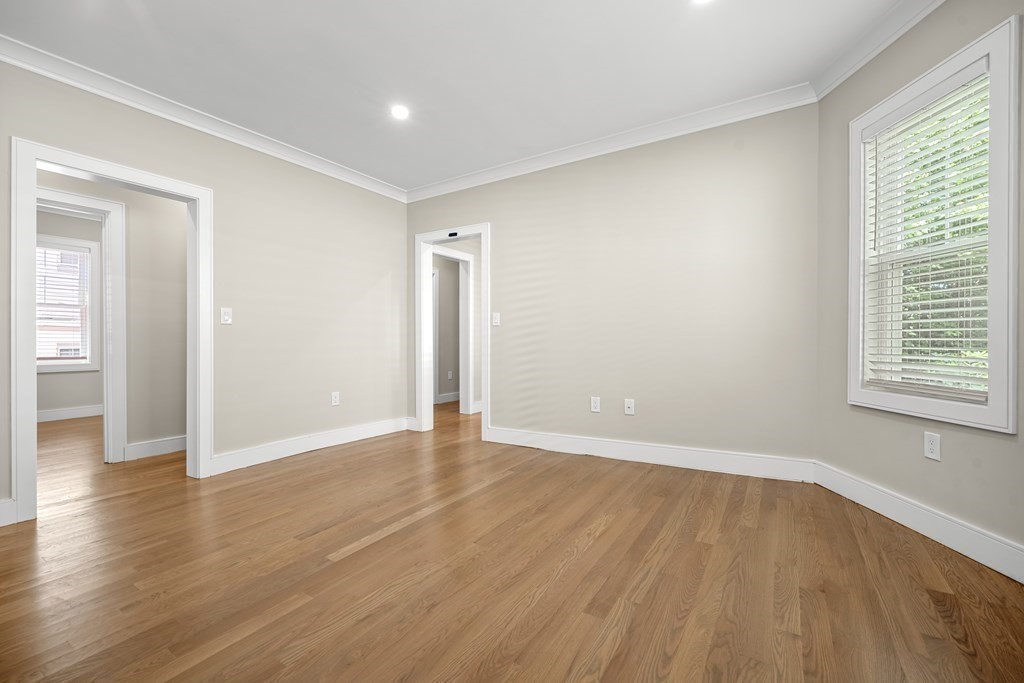 44 Iffley Road Boston, MA 02130 - Photo 3 of 19 a view of an empty room with wooden floor and a window