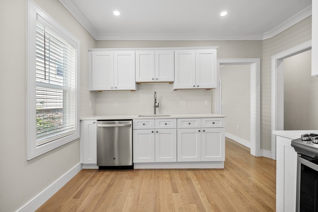 44 Iffley Road Boston, MA 02130 - Photo 9 of 19 a kitchen with white cabinets and a window