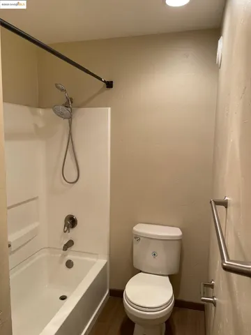 a white toilet sitting next to a bath tub and a shower