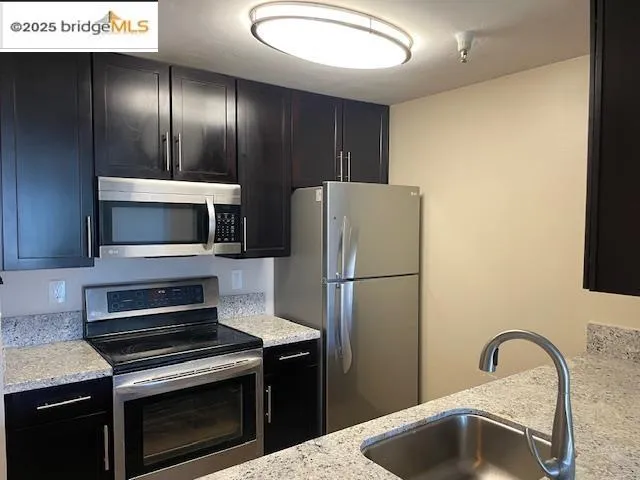 a kitchen with a sink and stainless steel appliances
