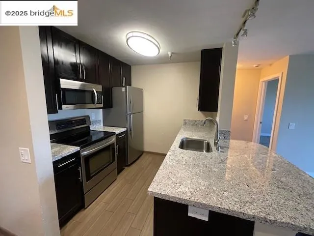 a kitchen with granite countertop stainless steel appliances and wooden cabinets