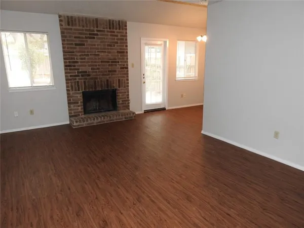 an empty room with wooden floor and fireplace