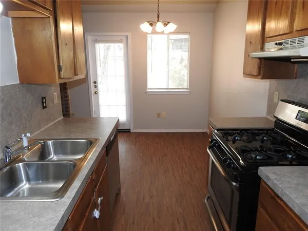 a kitchen with granite countertop a sink stove and refrigerator