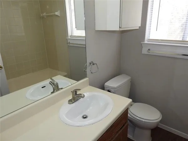 a bathroom with a sink a toilet and a window