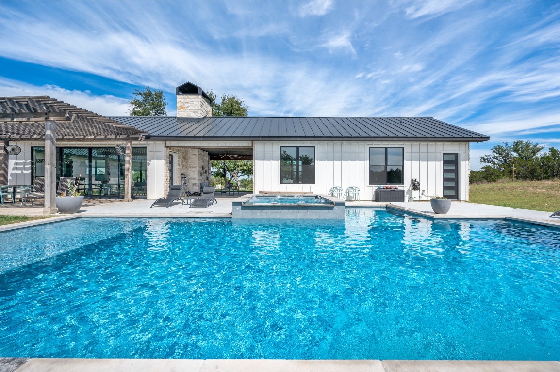 a swimming pool view with a seating space and a garden view