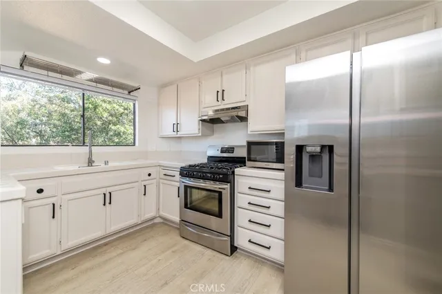 a kitchen with cabinets appliances and a window
