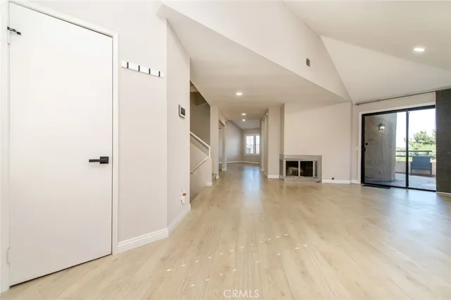 a view of a hallway with wooden floor and a fireplace