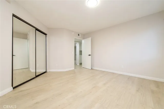 a bedroom with a bed and large windows