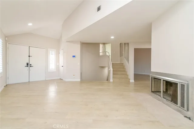 an empty room with a cabinet and mirrors