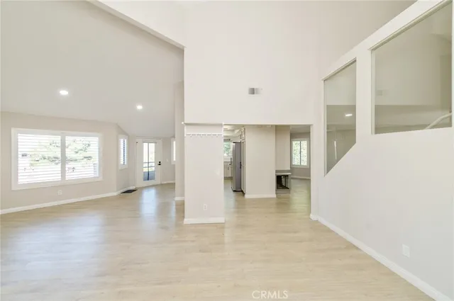 an empty room with windows and a fireplace