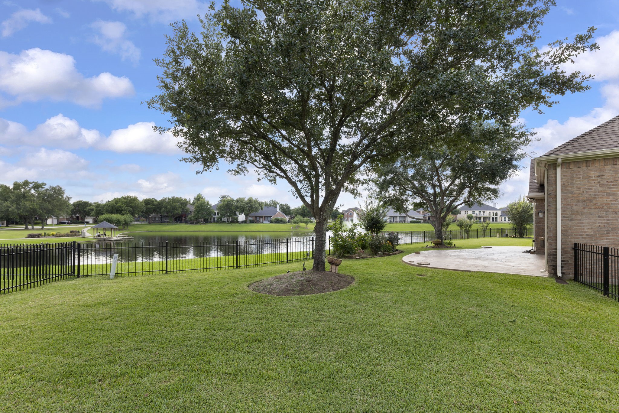 2907 Stemwood Drive Spring, TX 77388 - Photo 29 of 33 Expansive waterfront backyard featuring mature shade trees, lush green space, and an extended patio overlooking the lake—offering a peaceful setting for outdoor entertaining and everyday relaxation.