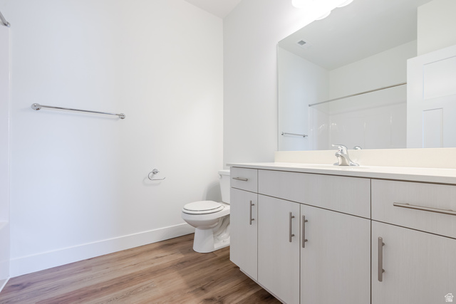 675 West 4500th South, Unit P302 Mapleton, UT 84664 - Photo 6 of 16 Bathroom featuring wood-finish flooring, a white vanity with brushed nickel hardware, a rectangular vanity mirror, and a white toilet