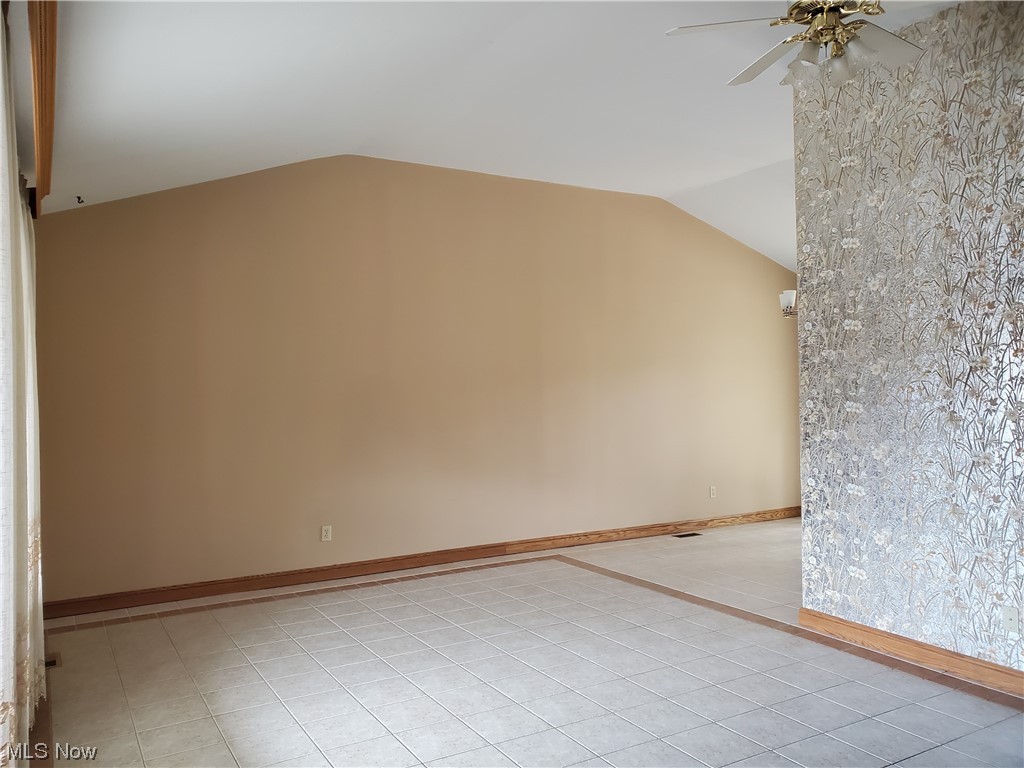 12221 Reno Drive Parma, OH 44130 - Photo 11 of 29 Tiled empty room with vaulted ceiling