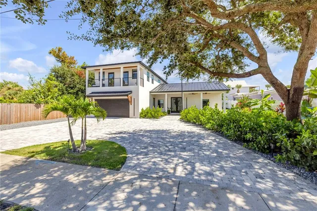 a kitchen with stainless steel appliances kitchen island granite countertop a refrigerator a stove a sink a dining table and chairs with wooden floor