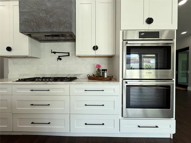 a kitchen with granite countertop white cabinets and white appliances