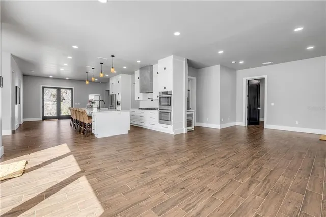 a view of empty room with wooden floor and ceiling fan